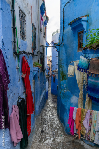 Tight and Narrow Blue Street in the Medina of Chefchaouen Morocco with Clothing for Sale © James