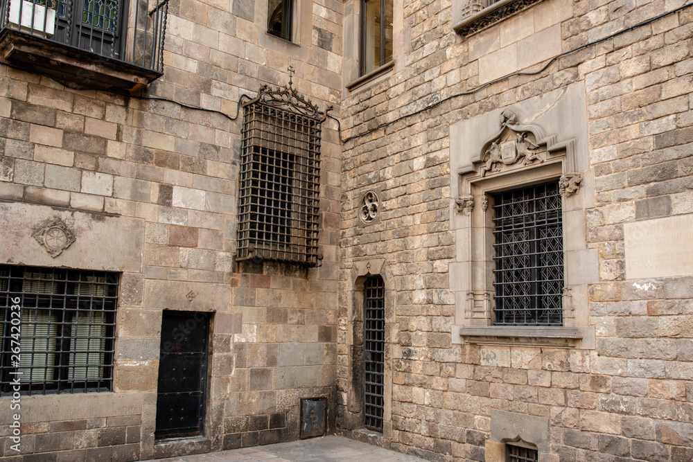 Windows in a facade of an old Medieval building in the Gothic Quarter (Barrio Gotico) in Barcelona, Spain