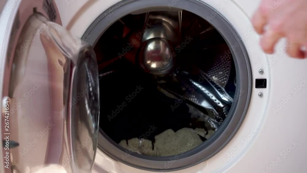 Loading dirty clothes to the washing machine, preparing laundry for washing Loading dirty clothes to the washing machine, preparing laundry for washing