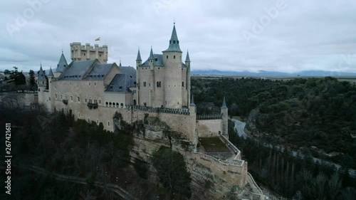 Aerial drone shot of magestic, magical and dreamy medieval ancient castle on top of hill, surrounded by old town or village. Inspirational travel wanderlust destination for blogger or tolkienists photo