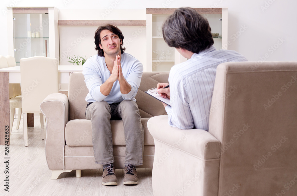 Young male patient discussing with psychologist personal problem Young male patient discussing with psychologist personal problem