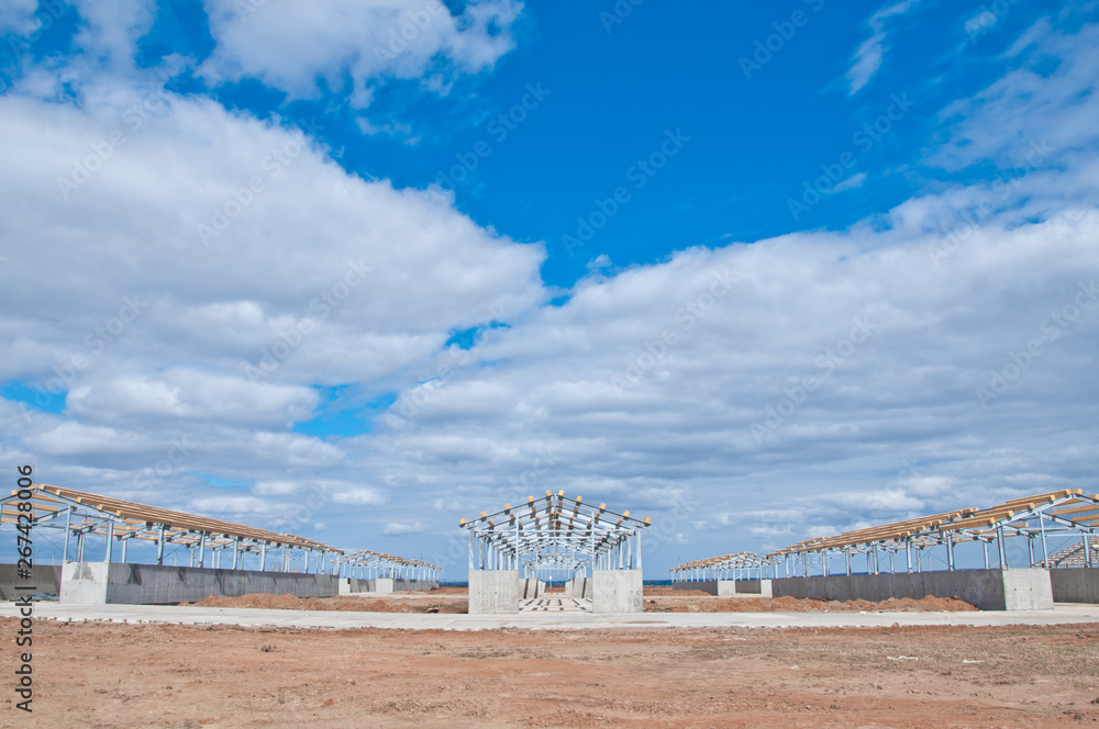 Fototapeta premium Reinforced concrete construction at the construction site. The use of concrete and metal frame for the construction of buildings and structures.
