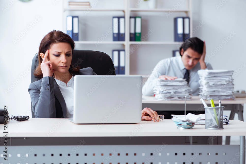 Old female boss and young male employee in the office Old female boss and young male employee in the office
