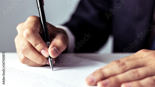 Businessman signing a document in office photo