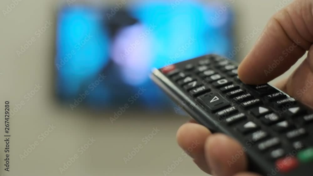 Man switches channels on the TV