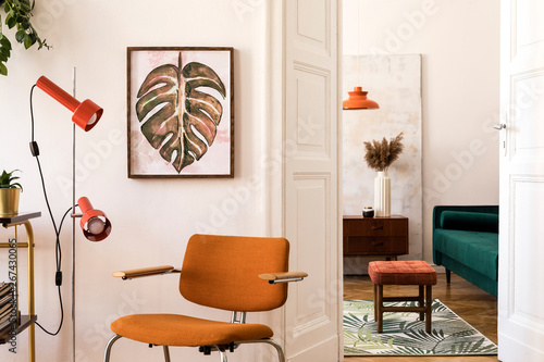 Fotografi Stylish compositon of retro home interior with mock up poster frame, vintage orange chair, velvet sofa, design lamps, gold shelf, plants and elegant accessories