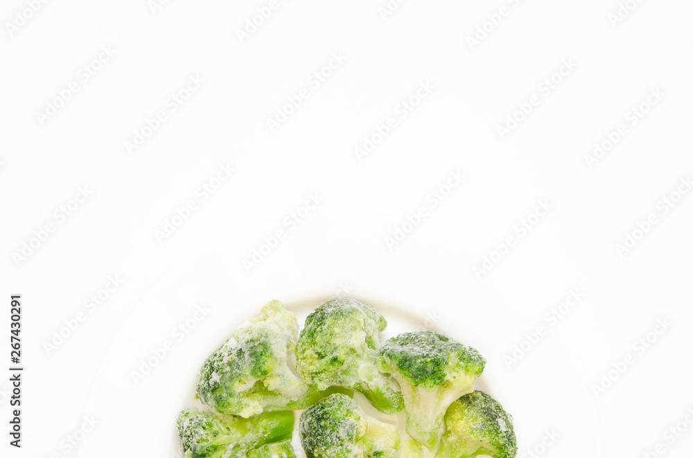 Frozen broccoli on a white plate. Top view, flat lay, copy space. Frozen broccoli on a white plate. Top view, flat lay, copy space.