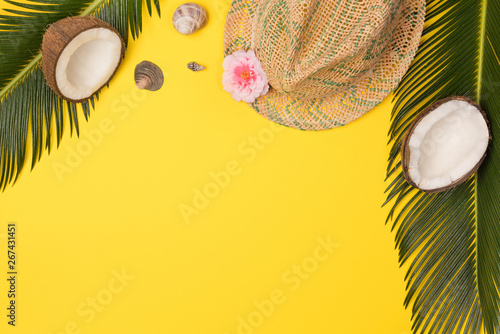 hat, coconuts and palm leaves isolated on yellow background, top view