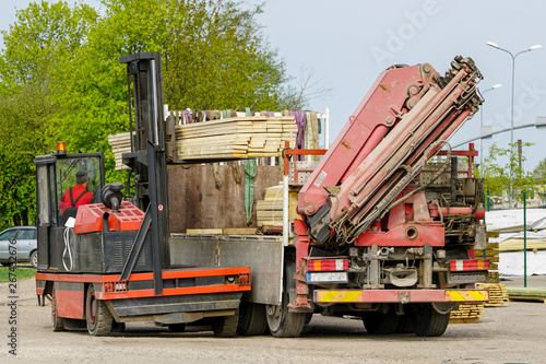 large lift truck load new wooden boards on truck