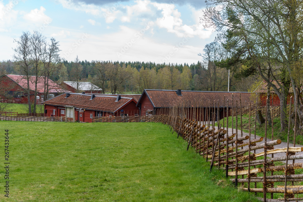 A typical traditional fence and old houses in Tyresta village, Sweden A typical traditional fence and old houses in Tyresta village, Sweden