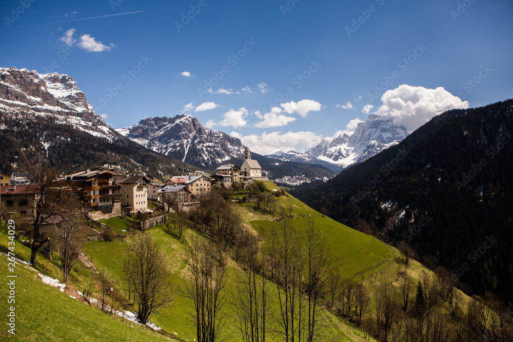 Beautiful mountain scenery in the Alps with fresh green meadows in bloom on a beautiful sunny day in springtime. Dolomiti montains in Italy. Landscape in spring in Europe. 