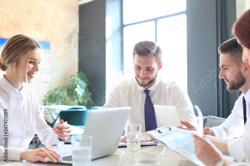 Group of business partners discussing ideas and planning work in office.