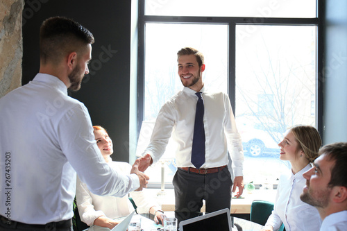 Businessman shaking hands to seal a deal with his partner and colleagues in office.