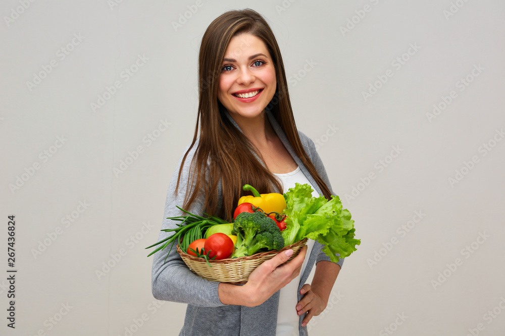 smiling woman holding vegetarian food in straw basket smiling woman holding vegetarian food in straw basket