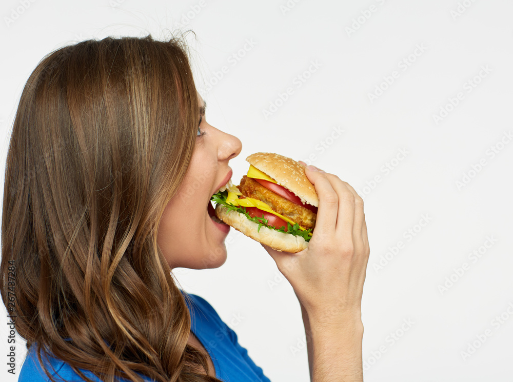 woman with long hair eating burger.