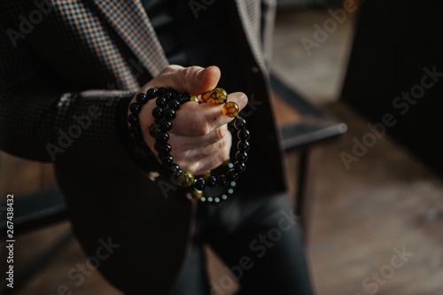 Rosary in the hands of a man in a jacket