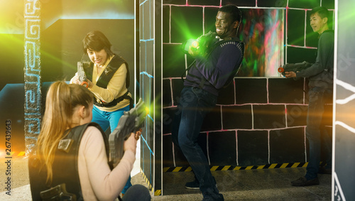 group of adult people with laser guns having fun