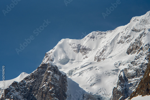 the peaks of the rocks and mountain peaks are covered with white snow against a blue sky. Kabardino-Balkaria  Russia