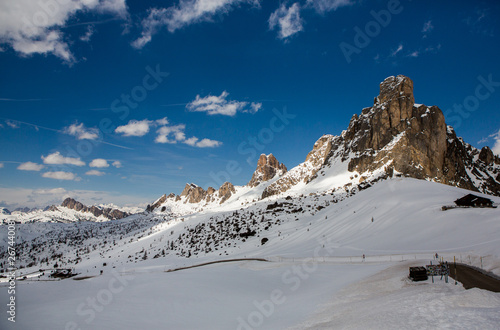 Beautiful winter landscape with snow in Alps. Dolomites. Panorama of snow mountain landscape with blue sky. Sunshine. Peaks. Rocks. Alps. Italy.