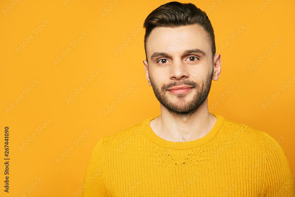 Obraz premium Close up portrait of happy handsome man in yellow is posing over orange background