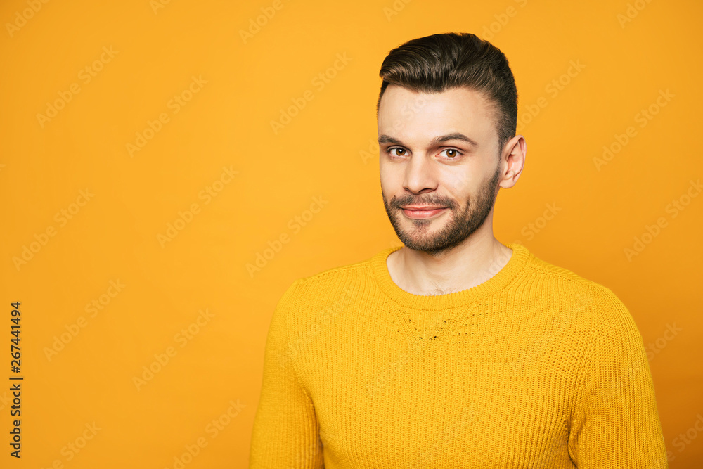 Close up portrait of happy handsome man in yellow is posing over orange background Close up portrait of happy handsome man in yellow is posing over orange background