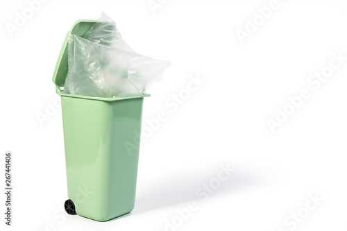 Green litter, trash, bin for wet waste or recycling bin with transparency plastic bag on it isolated on white background. Green gabage plastic bins for eco and recycling concept.