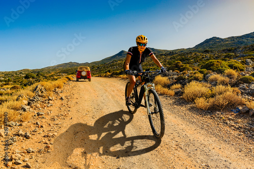 Cycling woman riding on bikes in Dolomites mountains andscape. Cycling MTB enduro trail track. Outdoor sport activity.