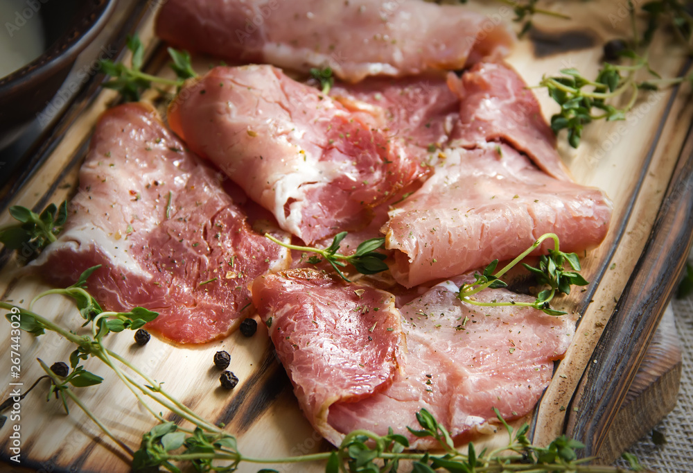 delicious pork bacon sliced into strips on a wooden background with spices and fresh thyme. A serving of low-fat succulent farm meat pork. Food Photography delicious pork bacon sliced into strips on a wooden background with spices and fresh thyme. A serving of low-fat succulent farm meat pork. Food Photography