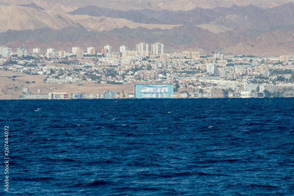 Israel flag waving along the shore of dead sea bay