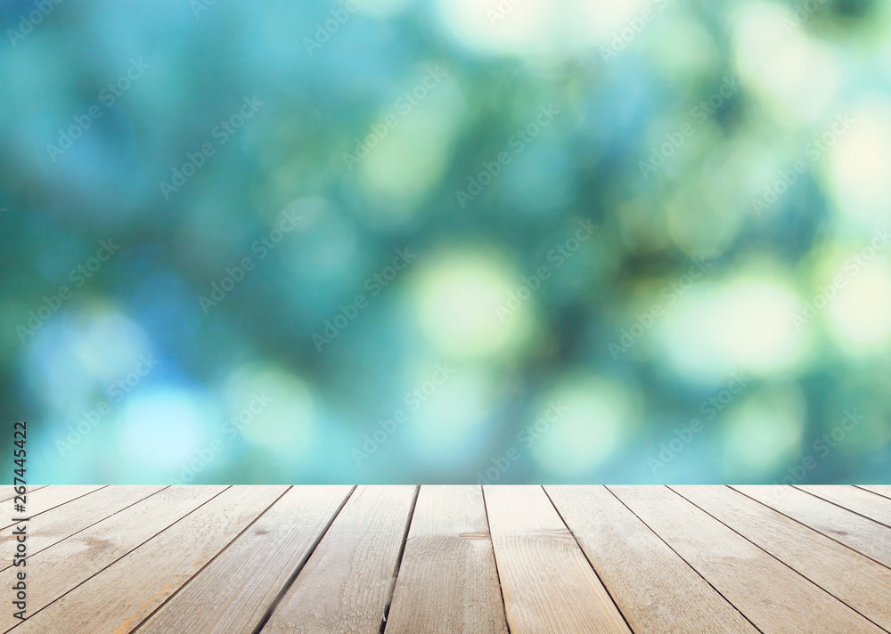 Empty wooden table, natural blurred greens on the background, the sun's rays Empty wooden table, natural blurred greens on the background, the sun's rays