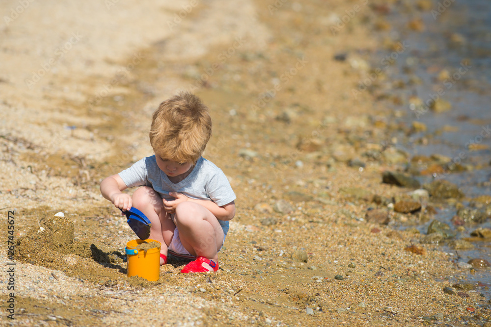 Boy plays on the beach. Summer rest. Summer holidays. Sea shore. Kids and sea sand. Boy plays on the beach. Summer rest. Summer holidays. Sea shore. Kids and sea sand.