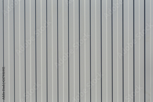 Fragment of a fence from the profiled sheet of gray. Abstract, geometric background. Concept: construction of modern durable materials.