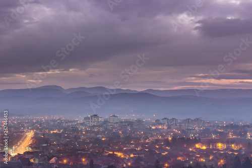 Dreamy, misty, blue hour cityscape of Pirot in Serbia taken from nearby viewpoint © Nikola