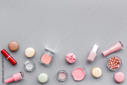 decorative cosmetics for make-up with macaroon cookies on gray tabletop background mockup