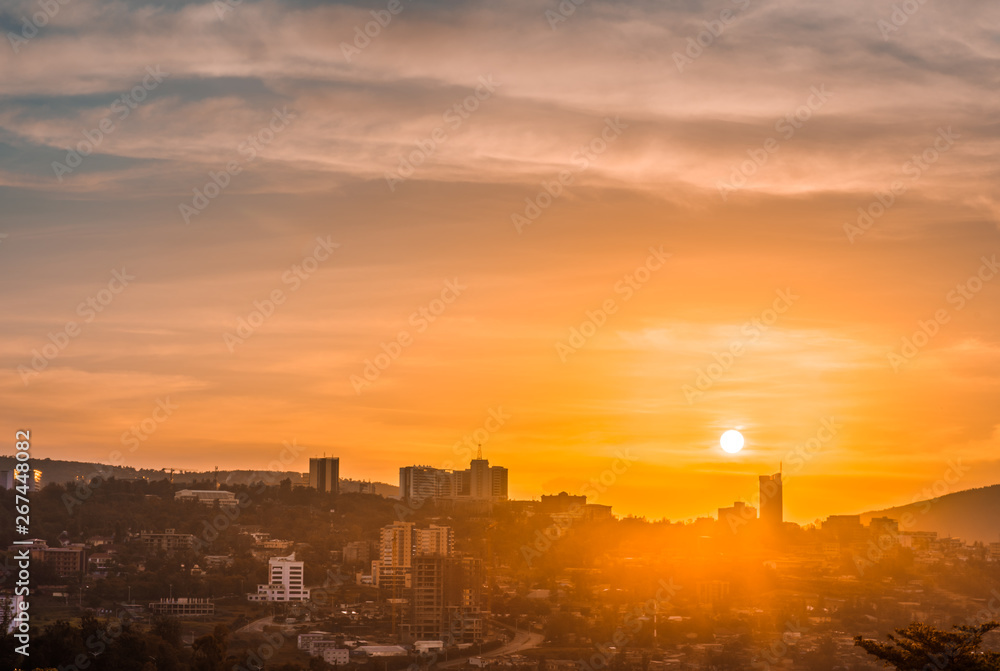 Kigali city centre skyline and surrounding areas under a golden sky at sunset