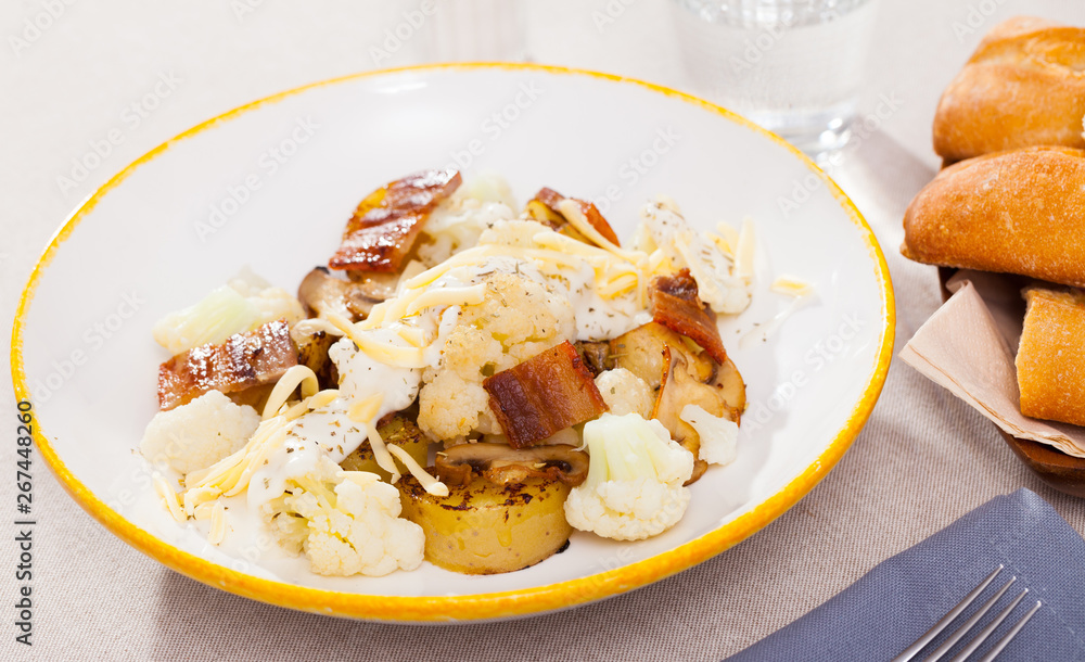 Dish of tasty baked cauliflower with potatoes, brisket meat and cheese sauce