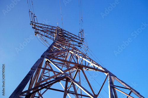 High-voltage power line pillar against the blue sky.