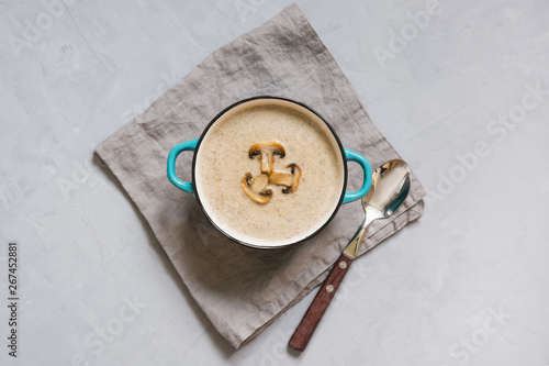 Delicious mushroom champignon soup on grey concrete table. Top view.