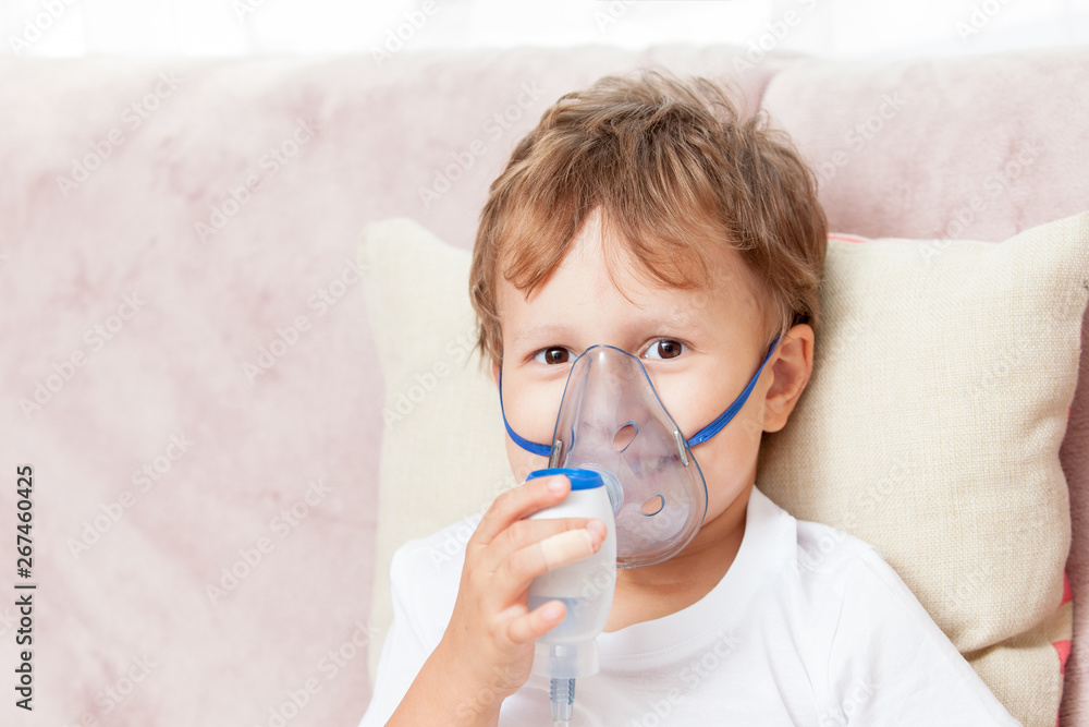 Boy making inhalation with a nebulizer at home Boy making inhalation with a nebulizer at home