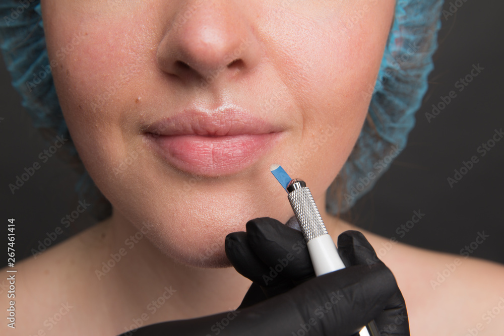 Obraz premium Microblading work flow in a beauty salon. Woman having her eye brows tinted. Semi-permanent makeup for eyebrows. Focus on model's face and eyebrow