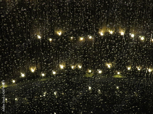 Regentropfen am Fenster mit Lichtern im Hintergrund