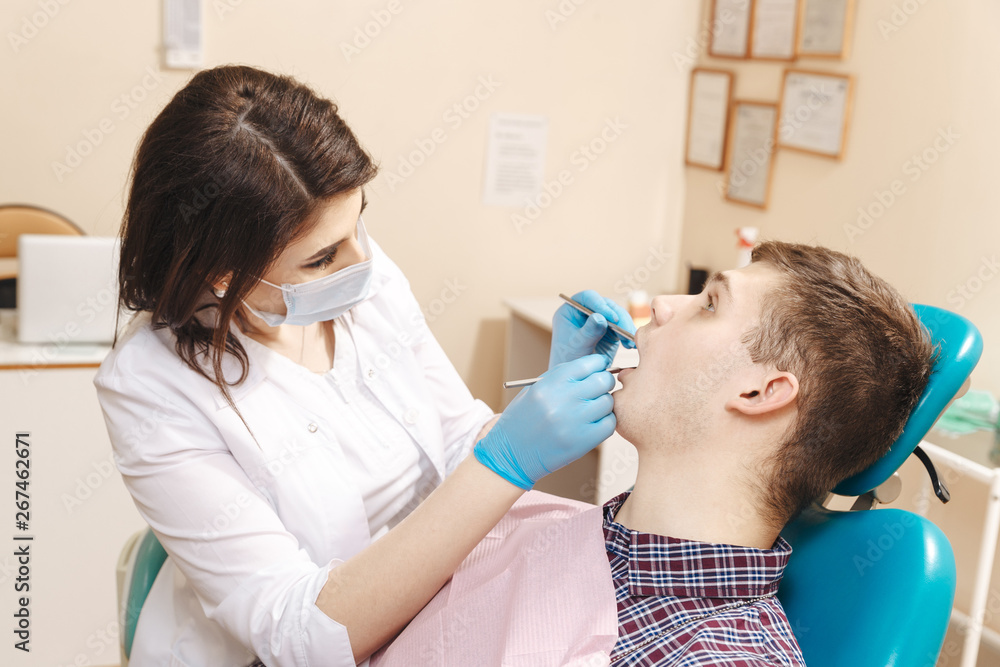 Young female dentist and her patient taking care to teeth Young female dentist and her patient taking care to teeth