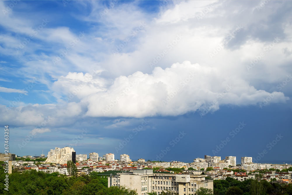 The picturesque sky over the city before a thunderstorm. A large white cloud in a stormy sky. Summer storm skyscape