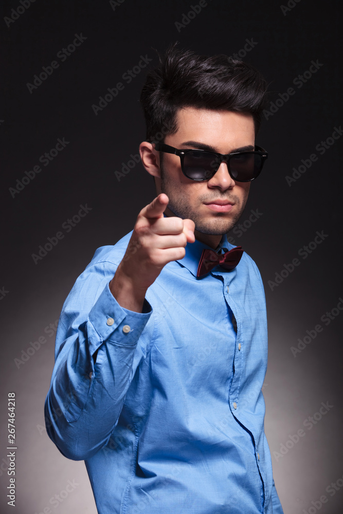 Serious looking young male pointing at the camera Serious looking young male pointing at the camera