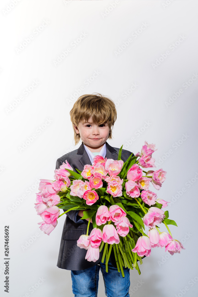 Little boy with pink tulips. Cute small kid holds bouquet of tulips. Boy with flowers in hands. Toddler boy in suit hold tulips. Cute gentleman boy presenting bouquet of tulips. Valentines day. Spring Little boy with pink tulips. Cute small kid holds bouquet of tulips. Boy with flowers in hands. Toddler boy in suit hold tulips. Cute gentleman boy presenting bouquet of tulips. Valentines day. Spring