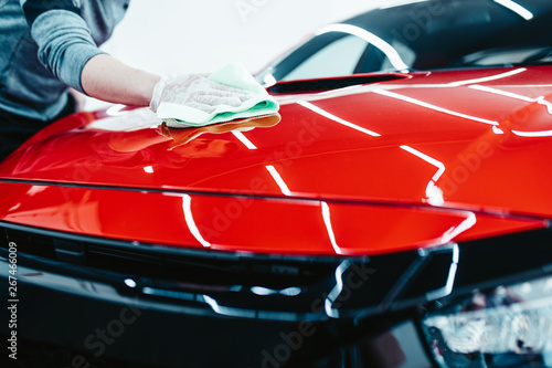 A man cleaning car with cloth, car detailing (or valeting) concept. Selective focus.