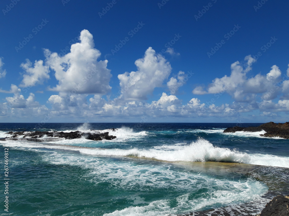  ocean view with waves splashing on rocky coast -