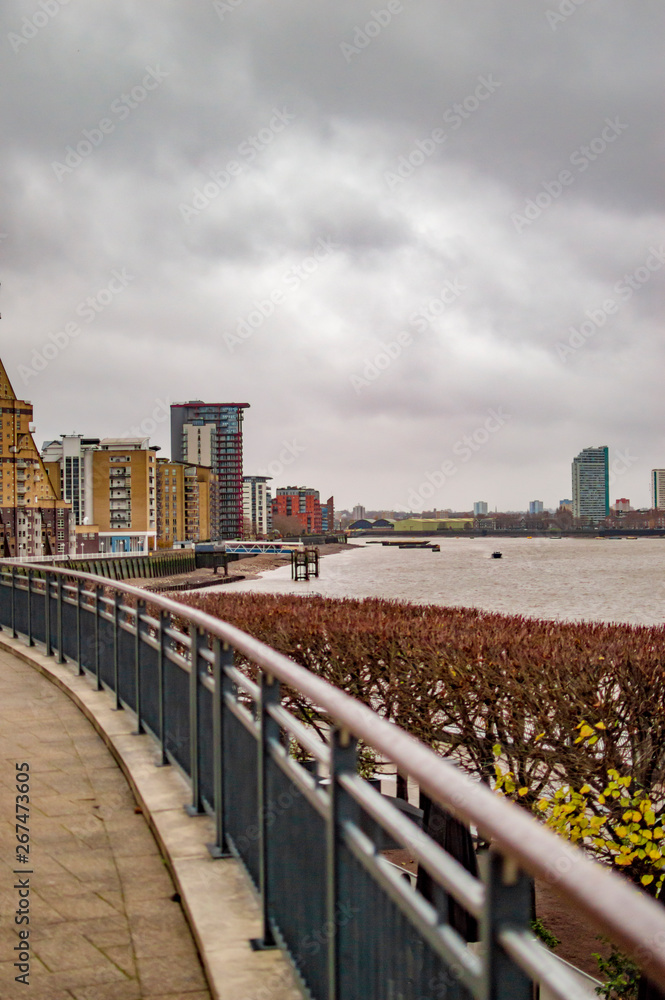 Canary wharf with thames in london and the road with fencing