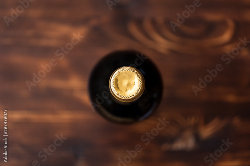 A dark bottle of wine blurry on a wooden background.