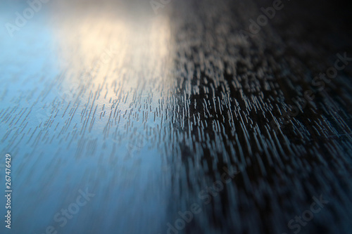 The table surface is wooden textured macro photo of a beam of light as the background.